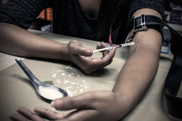 La jeringa con el medicamento en la mano en el suelo — Foto de Stock