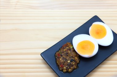 Tay gıda, chili yapıştırın siyah dikdörtgen tabak haşlanmış yumurta ile,