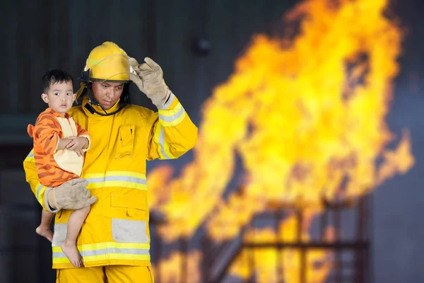 Strażak, strażak uratował dziecko od ognia — Zdjęcie stockowe