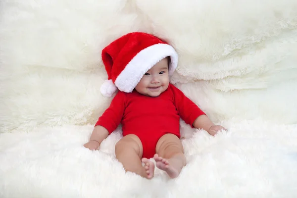Bonito cinco meses asiático bebê sorrindo com chapéu de Papai Noel., no tapete macio brilhante — Fotografia de Stock