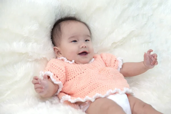Bonito cinco meses asiático bebê em vestido laranja rindo., no tapete macio brilhante . — Fotografia de Stock