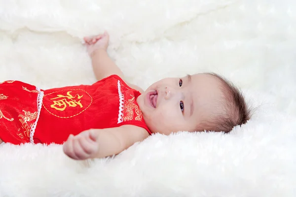 Симпатичные пять месяцев азиатский ребенок улыбается в красном Чонгсам., на яркий — стоковое фото