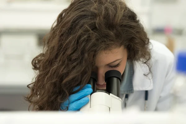 Joven estudiante que trabaja con un microscopio Imagen de archivo