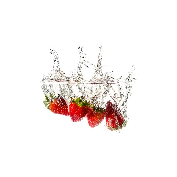 Strawberries splash on water, isolated on white background. — Stock Photo, Image