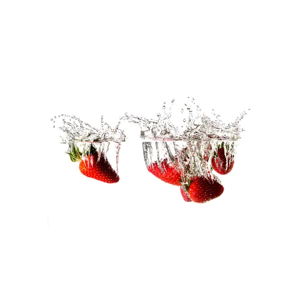 Salpicos de morangos na água, isolados sobre fundo branco — Fotografia de Stock