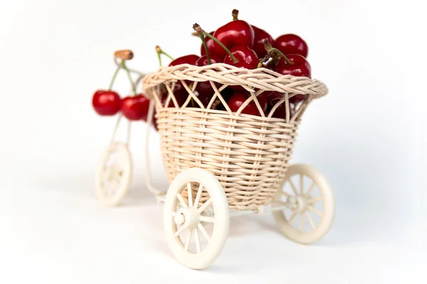 Cerejas em cesta decorativa em uma bicicleta, isolado — Fotografia de Stock