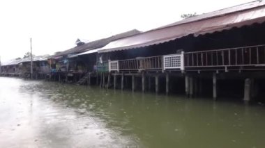 Yağmurda uzun kuyruklu bir nehir teknesinden terk edilmiş Amphawa Yüzen Pazarı
