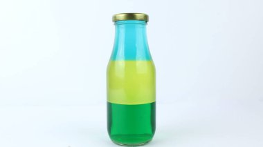 Şişenin üst katmanında su, zeytinyağı ve alkolden oluşan üç ayrı katman kullanarak sıvı veya katman yoğunluğu deneyi. Yoğunluk bilimi konsepti