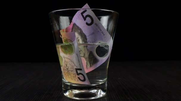 Μουλιάστε Αυστραλιανά Δολάρια Ένα Ποτήρι Γεμάτο Ισοπροπυλική Αλκοόλη Και Νερό — Αρχείο Βίντεο