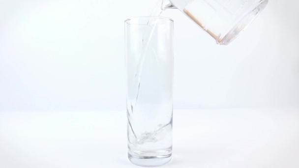 白い背景に澄んだ水をグラスカップに入れる — ストック動画