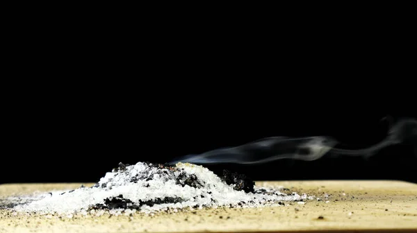 Potasyum permanganat KMnO4 ve Şeker deneyleri. Potasyum permanganat ve şeker yangın çıkarabilir. Siyah arkaplanda resim