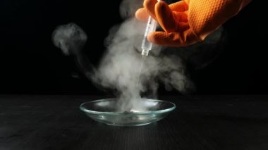 Potasyum Permanganat Hidrojen Peroksit Çürüme Reaksiyonu. KMno4 ve H2O2 'nin kimyasal reaksiyonunun duman etkisi. Siyah zemin üzerinde tehlikeli bir deney.