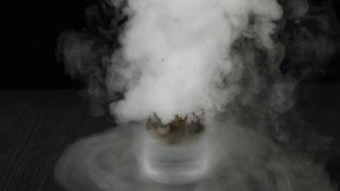 Potasyum Permanganat Hidrojen Peroksit Çürüme Reaksiyonu. KMno4 ve H2O2 'nin kimyasal reaksiyonunun duman etkisi. Siyah zemin üzerinde tehlikeli bir deney.