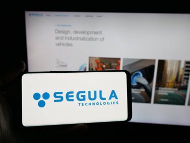 Stuttgart, Almanya - 10-06-2025: Mühendislik şirketi Segula Technologies 'in logosunun bulunduğu akıllı telefonu web sitesinin önünde tutan kişi. Telefon ekranına odaklan.