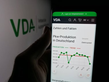Stuttgart, Almanya - 10-06-2025: Logonun önündeki ekranda Almanca Verband der Automobidustrie 'nin (VDA) web sayfası bulunan kişi. Telefon ekranının merkezine odaklan.