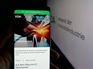 Stuttgart, Almanya - 10-06-2025: Logonun önündeki ekranda Almanca Verband der Automobidustrie (VDA) web sayfası bulunan kişi. Telefon ekranının merkezine odaklan.