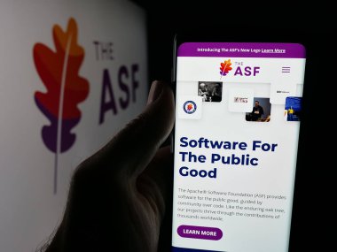 Stuttgart, Almanya - 10-08-2025: Apache Yazılım Vakfı (ASF) örgütünün web sayfası logonun önünde cep telefonu tutan kişi. Telefon ekranının merkezine odaklan.