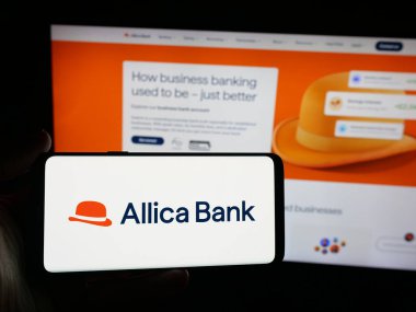 Stuttgart, Almanya - 10-09-2025: İngiliz bankacılık şirketi Allica Bank Limited 'in logosuna sahip akıllı telefon sahibi kişi web sitesinin önünde ekranda. Telefon ekranına odaklan.