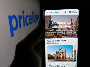 Stuttgart, Almanya - 10-09-2025: ABD 'li çevrimiçi seyahat şirketi Priceline.com LLC' nin web sayfası ile akıllı telefon sahibi kişi logo önünde ekranda. Telefon ekranının merkezine odaklan.