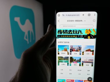 Stuttgart, Almanya - 10-09-2025: Çin çevrimiçi seyahat şirketi Qunar.com 'un internet sayfası ile akıllı telefonu olan kişi logonun önünde ekranda. Telefon ekranının merkezine odaklan.