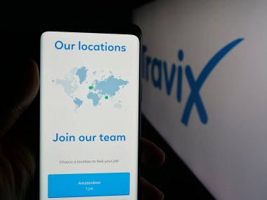 Stuttgart, Almanya - 10-09-2025: Seyahat şirketi Travix International B.V. 'nin web sayfası ile akıllı telefonu olan kişi logonun önünde ekranda. Telefon ekranının merkezine odaklan.
