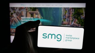 Stuttgart, Almanya - 10-09-2025: SMG İsviçre Piyasa Grubu AG logosuna sahip cep telefonu sahibi kişi web sayfası önünde ekranda. Telefon ekranına odaklan.