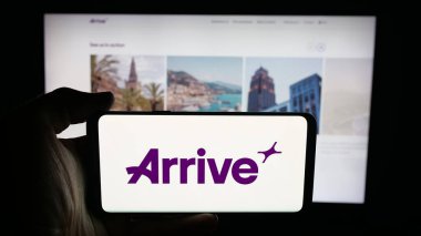 Stuttgart, Almanya - 10-09-2025: İsveçli akıllı hareketlilik şirketinin logosunun bulunduğu cep telefonu sahibi kişi web sayfasının önünde ekranda. Telefon ekranına odaklan.