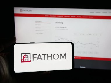 Stuttgart, Almanya - 10-09-2025: ABD 'li emlak şirketi Fathom Holding Inc.' in logosunun bulunduğu akıllı telefon web sitesinin önünde ekranda. Telefon ekranına odaklan.