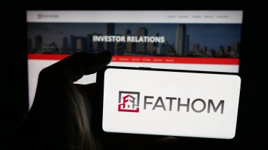 Stuttgart, Almanya - 10-09-2025: ABD 'li emlak şirketi Fathom Holding Inc.' in logosunun bulunduğu cep telefonu web sitesinin önünde ekranda. Telefon ekranına odaklan.