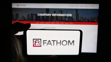Stuttgart, Almanya - 10-09-2025: ABD 'li emlak şirketi Fathom Holding Inc.' in logosunun bulunduğu cep telefonu web sayfasının önünde ekranda. Telefon ekranına odaklan.