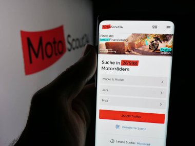 Stuttgart, Almanya - 10-09-2025: Motosiklet pazarı şirketi MotoScout24 'ün web sitesi ile akıllı telefon sahibi kişi logonun önünde ekranda. Telefon ekranının merkezine odaklan.