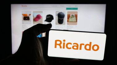 Stuttgart, Almanya - 10-09-2025: İnternet sayfası önünde üzerinde pazarlama şirketi Ricardo (Ricardo.ch) logosu bulunan cep telefonu sahibi kişi. Telefon ekranına odaklan.