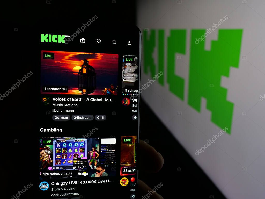 Stuttgart, Germany - 10-06-2025: Person holding cellphone with webpage of video livestreaming platform company Kick.com on screen in front of logo. Focus on center of phone display.