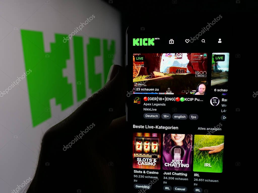 Stuttgart, Germany - 10-06-2025: Person holding smartphone with web page of video livestreaming platform company Kick.com on screen in front of logo. Focus on center of phone display.
