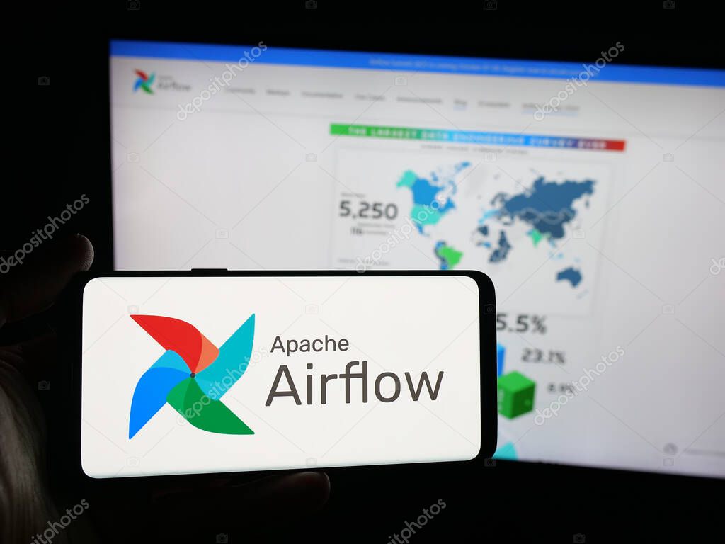 Stuttgart, Germany - 10-08-2025: Person holding smartphone with logo of workflow management platform Apache Airflow on screen in front of website. Focus on phone display.