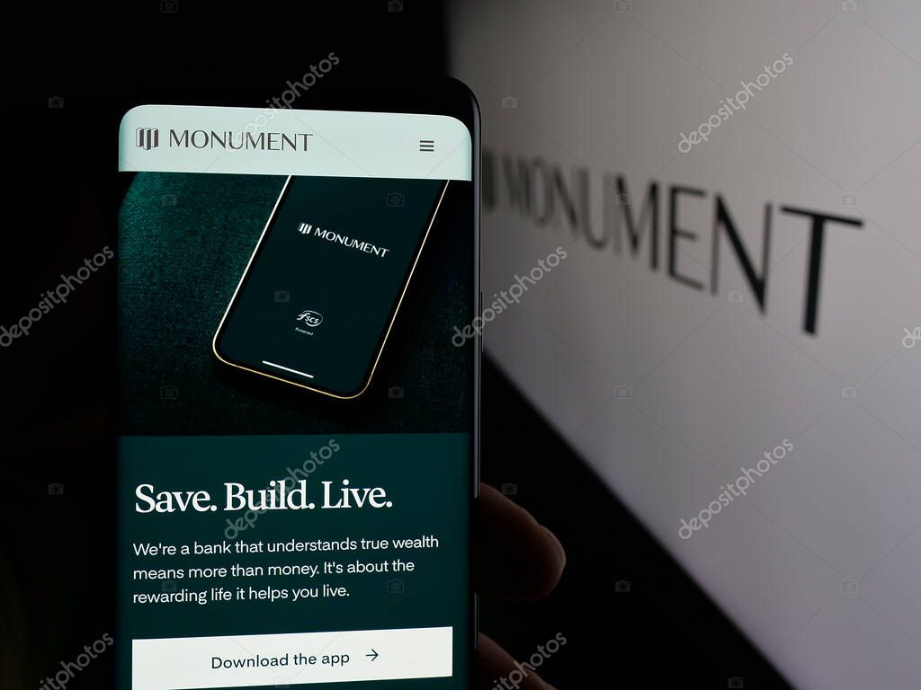 Stuttgart, Germany - 10-08-2025: Person holding smartphone with web page of British banking company Monument Bank Limited on screen in front of logo. Focus on center of phone display.