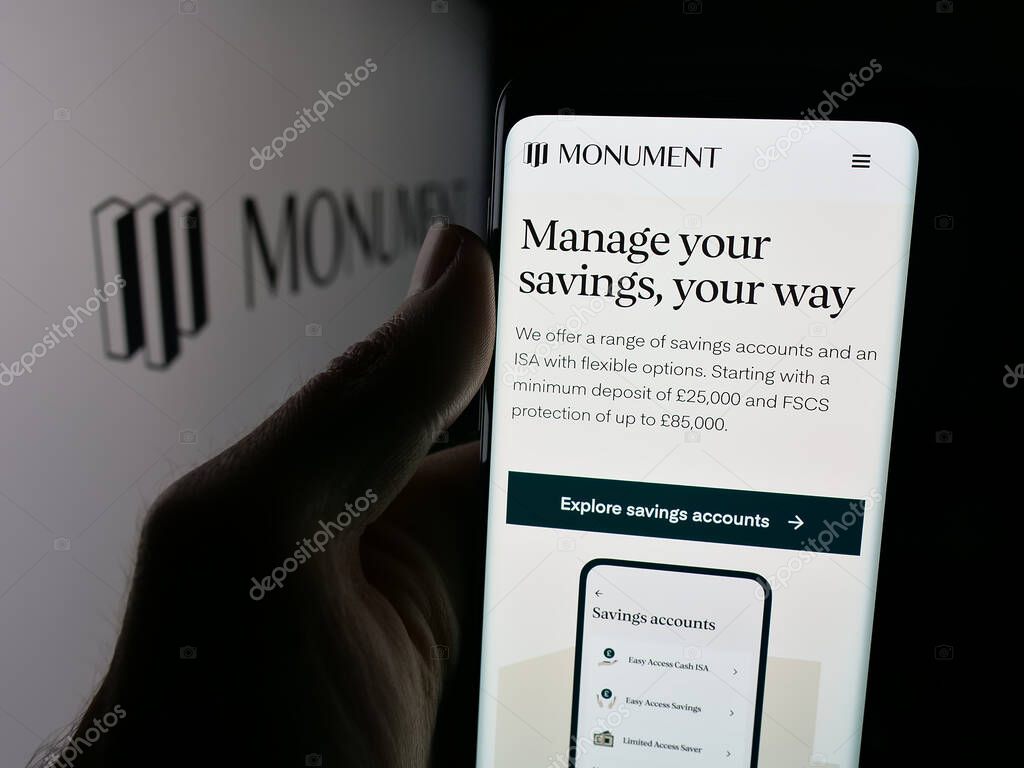 Stuttgart, Germany - 10-08-2025: Person holding cellphone with webpage of British banking company Monument Bank Limited on screen in front of logo. Focus on center of phone display.