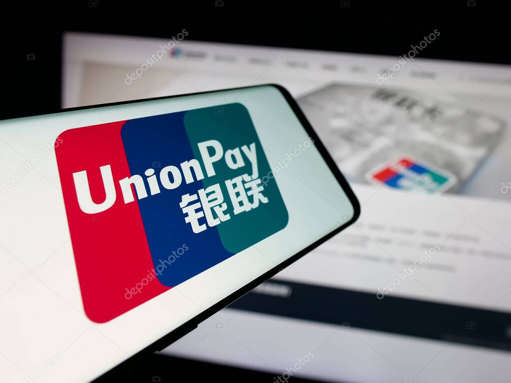 Stuttgart, Germany - 10-08-2025: Smartphone with logo of Chinese credit card company China UnionPay on screen in front of website. Focus on center-left of phone display.