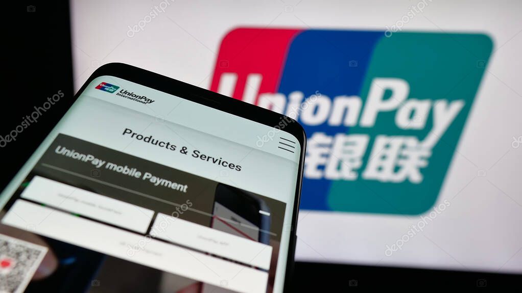 Stuttgart, Germany - 10-08-2025: Mobile phone with website of Chinese credit card company China UnionPay on screen in front of logo. Focus on top-left of phone display.