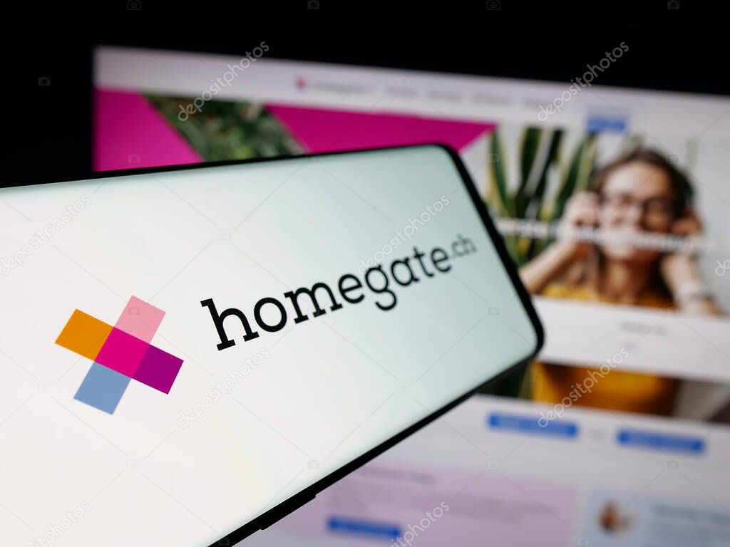 Stuttgart, Germany - 10-09-2025: Smartphone with logo of Swiss real estate portal company Homegate on screen in front of website. Focus on left of phone display.