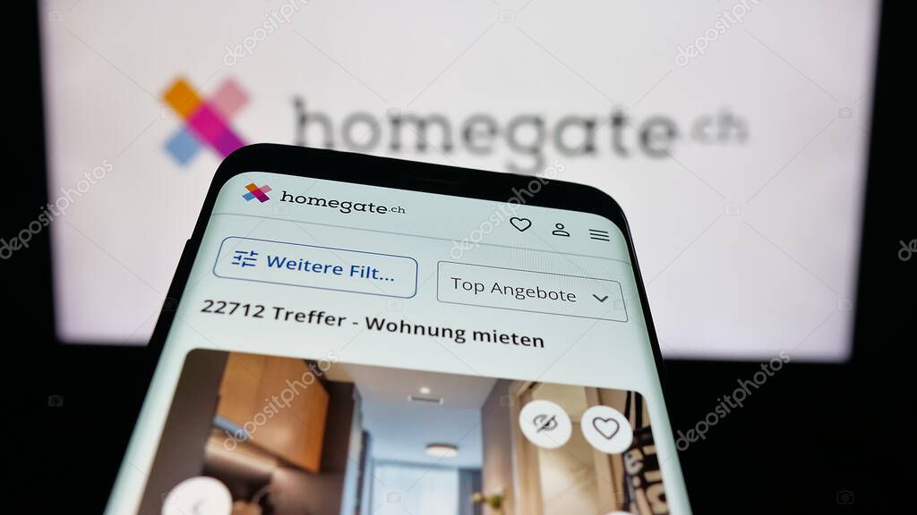Stuttgart, Germany - 10-09-2025: Mobile phone with website of Swiss real estate portal company Homegate on screen in front of logo. Focus on top-left of phone display.