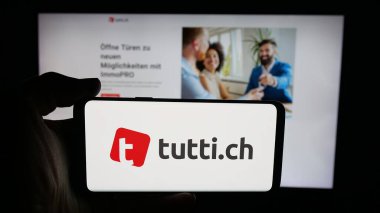Stuttgart, Almanya - 10-09-2025: Üzerinde İsviçre sınıflandırmaları platform şirket tutti.ch logosu bulunan cep telefonu web sayfası önünde ekranda. Telefon ekranına odaklan.