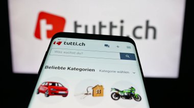 Stuttgart, Almanya - 10-09-2025: İsviçre 'de sınıflandırılan platform şirketi tutti.ch siteli cep telefonu logonun önünde ekranda. Telefon ekranının sol üst kısmına odaklan.