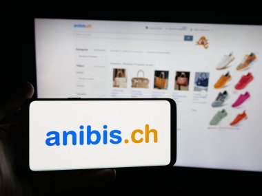 Stuttgart, Almanya - 10-09-2025: Üzerinde İsviçreli sınıflandırmacıların logosu bulunan akıllı telefon sahibi kişi platform şirketi anibis.ch 'i web sitesinin önünde ekranda gösteriyor. Telefon ekranına odaklan.