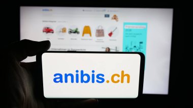 Stuttgart, Almanya - 10-09-2025: Cep telefonunda İsviçre 'de sınıflandırılmış platform şirketi anibis.ch logosu olan kişi web sayfasının önünde ekranda. Telefon ekranına odaklan.