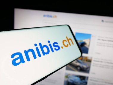 Stuttgart, Almanya - 10-09-2025: İsviçre amblemli akıllı telefon platform şirketi anibis.ch 'i web sitesinin önünde ekranda gösteriyor. Telefon ekranının merkez soluna odaklan.