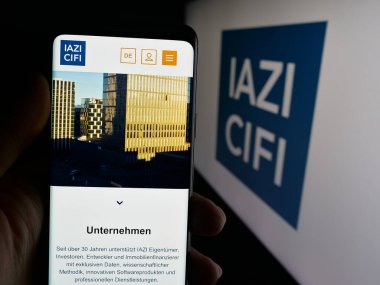 Stuttgart, Almanya - 10-10-2025: Emlak hizmetleri şirketi IAZI AG 'nin (CIFI SA) web sayfası olan cep telefonu logonun önünde ekranda. Telefon ekranının merkezine odaklan.