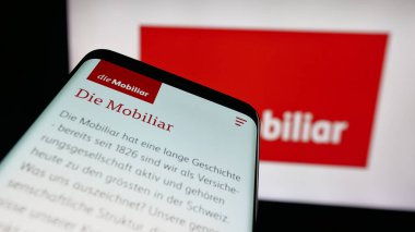 Stuttgart, Almanya - 10-10-2025: İsviçre sigorta şirketi Mobiliar 'ın web sitesinin bulunduğu cep telefonu logonun önünde ekranda. Telefon ekranının sol üst kısmına odaklan.