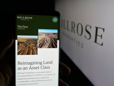 Stuttgart, Almanya - 10-10-2025: ABD 'li emlak şirketi Millrose Properties Inc.' in web sayfası ile akıllı telefon sahibi kişi logonun önünde ekranda. Telefon ekranının merkezine odaklan.