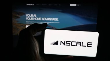 Stuttgart, Almanya - 10-10-2025: Nscale Global Holding Limited şirketinin logosuna sahip cep telefonu sahibi kişi web sayfasının önünde ekranda. Telefon ekranına odaklan.